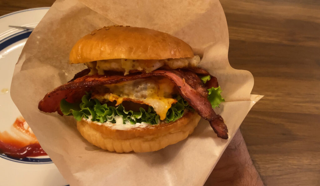 バーガーズタイム IMUAのベーコンチーズバーガーをひと口かぶりつくと、ジューシーな肉汁があふれ、ベーコンの塩気とチーズのコクが絶妙に合わさっていました。